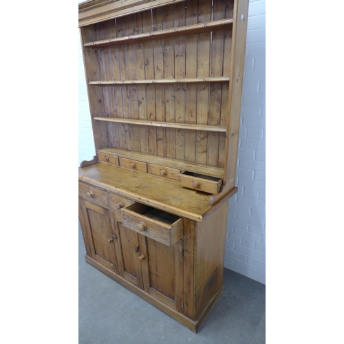 216 - Large pine kitchen dresser, with stepped cornice over shelved plate back with four short spice drawe... 