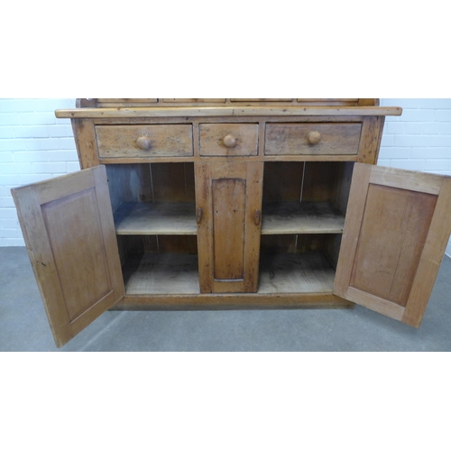 216 - Large pine kitchen dresser, with stepped cornice over shelved plate back with four short spice drawe... 