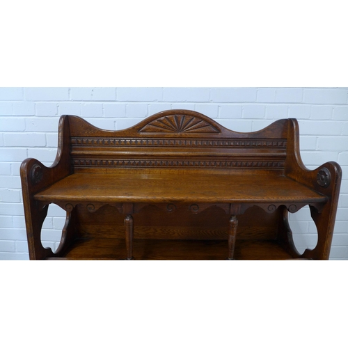 227 - An early 20th century oak open bookcase , the wavy top with dentil and fan carved detail, with quatr... 