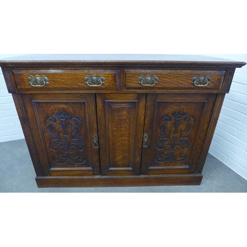 230 - An oak sideboard, moulded rectangular top above two short frieze drawers and two cupboard doors rais... 