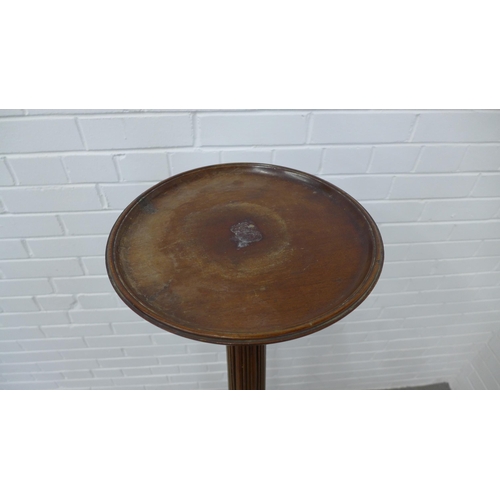 239 - Mahogany torchere stand, the circular dished top on a reeded column and tripod base. 138 x 57cm.