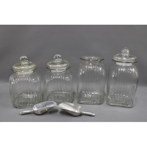 317 - Four modern glass storage jars, tallest 35cm, three with domed lids, together with two metal scoops,... 