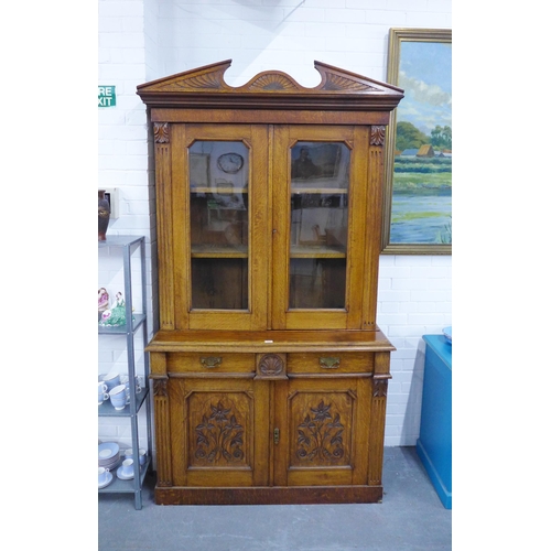 277 - Late 19th / early 20th century oak bookcase cabinet with a broken swan neck top over a  pair of glaz... 