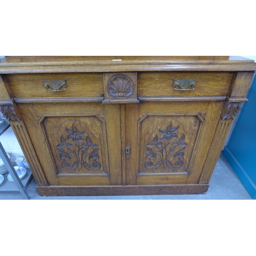 277 - Late 19th / early 20th century oak bookcase cabinet with a broken swan neck top over a  pair of glaz... 