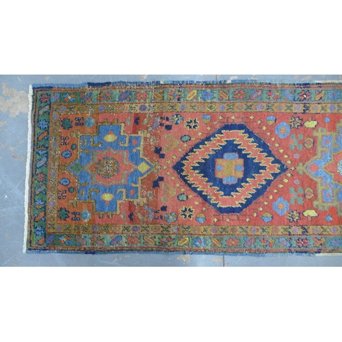 201 - Late 19th / early 20th century Persian runner, red field with five medallions within flowerhead bord... 