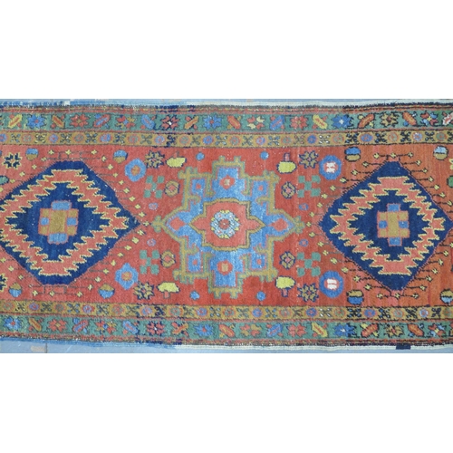 201 - Late 19th / early 20th century Persian runner, red field with five medallions within flowerhead bord... 