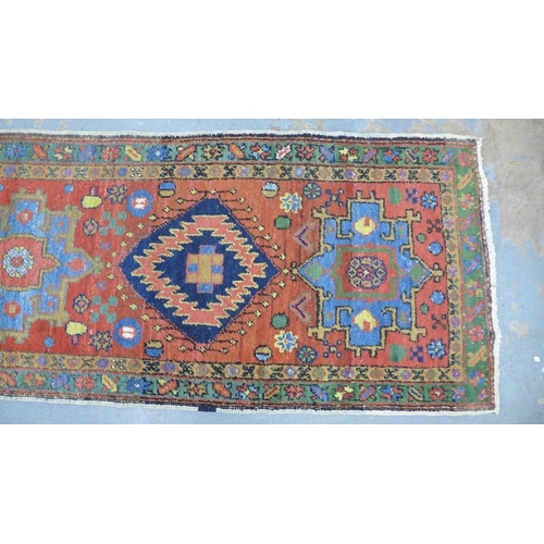 201 - Late 19th / early 20th century Persian runner, red field with five medallions within flowerhead bord... 