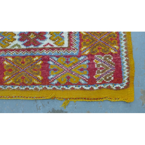 202 - 20th century  Moroccan rug, orange field with two  medallions within multiple flowerhead borders, wi... 