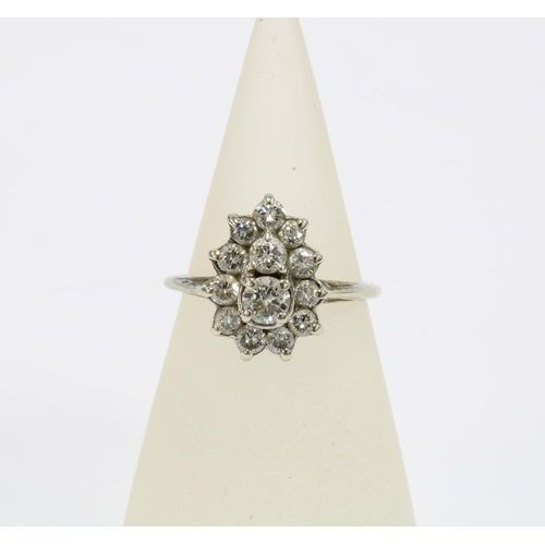 21 - Diamond cluster ring, claw set with two graduating central diamonds within a surround of eleven brig... 
