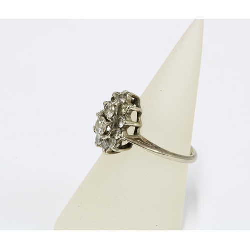21 - Diamond cluster ring, claw set with two graduating central diamonds within a surround of eleven brig... 