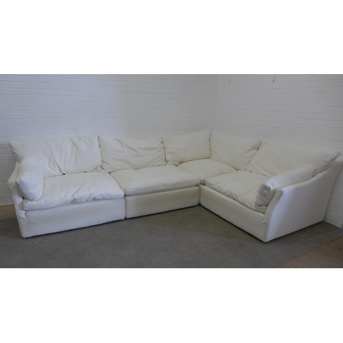 219 - Large sectional corner sofa group, in four parts, with cream covers and squab cushions, all covering... 