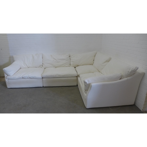 219 - Large sectional corner sofa group, in four parts, with cream covers and squab cushions, all covering... 