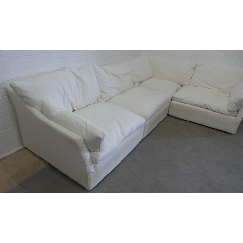 219 - Large sectional corner sofa group, in four parts, with cream covers and squab cushions, all covering... 