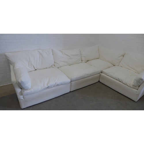 219 - Large sectional corner sofa group, in four parts, with cream covers and squab cushions, all covering... 