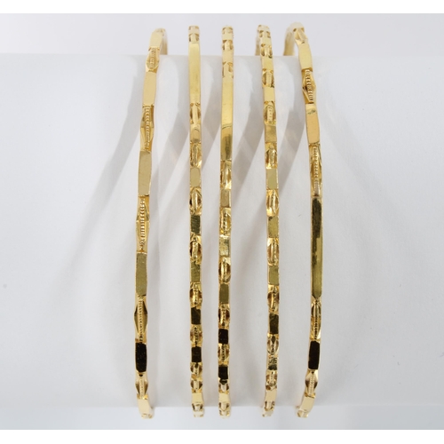 37 - Set of five unmarked gold bangles, each with alternating  textured and polished panels, likely Afric... 