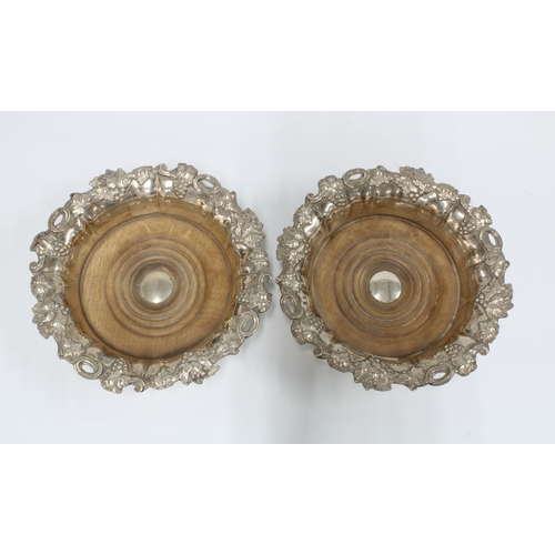 51 - A pair of Sheffield plate wine coasters, Henry Wilkinson, with turned wood bases and fruit and vine ... 