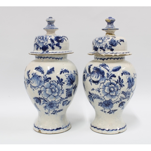 98 - A pair of delft blue and white lidded vases with mixed flowers and wavy bottom border, (2) (some dam... 