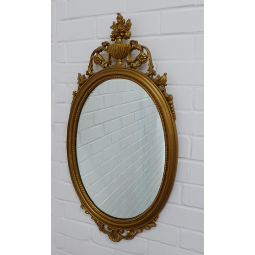 416 - Reproduction faux gilt framed mirror with a classical urn surmount over an oval mirrored plate. 79 x... 