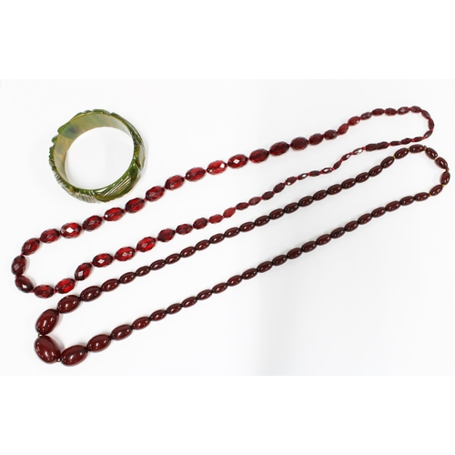 29 - A vintage strand of faux cherry amber beads, a green bangle and a strand of faceted beads, (3)