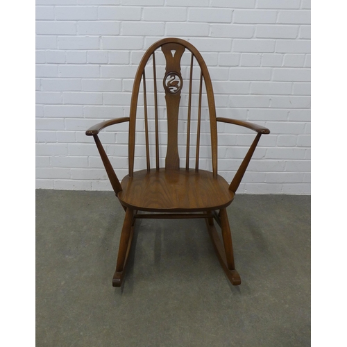 254 - An Ercol elm and beech rocking chair with swan splat back. 92 x 65cm