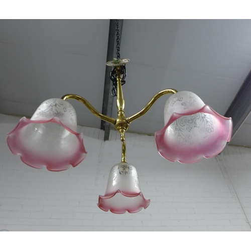 298 - Christopher Wray brass three branch light fitting with pink and white glass shades, 40cm.