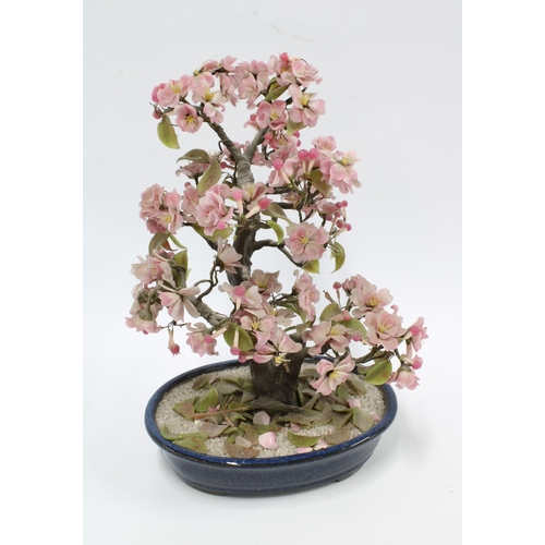 334 - Hardstone plant with pink flowers and green leaves, in a blue ceramic planter, 33cm.