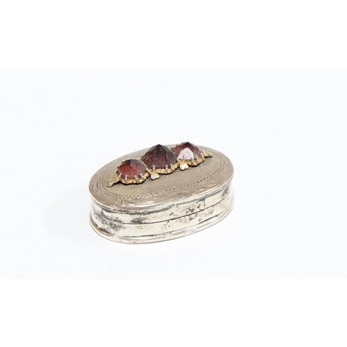 381 - Small silver pill box, the hinged lid with three garnets, stamped 925, 3cm