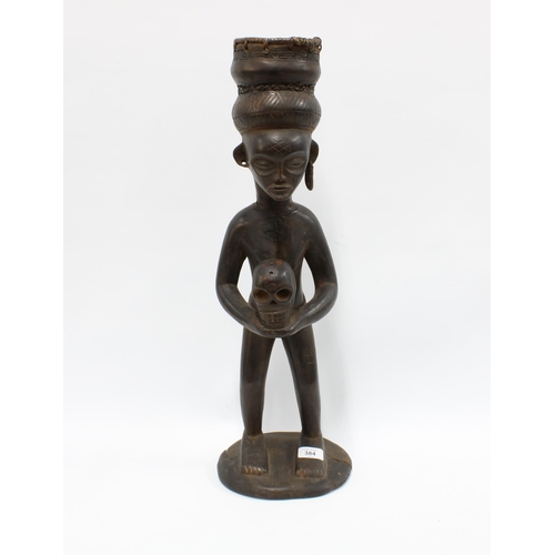 384 - Congo, carved wooden African figure, modelled standing and holding a skull, 63cm high