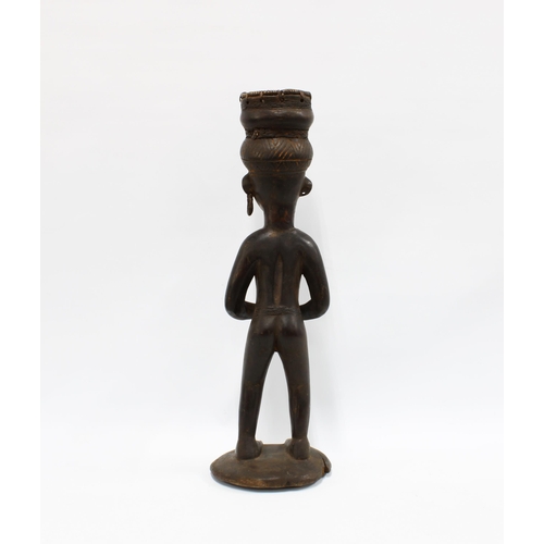 384 - Congo, carved wooden African figure, modelled standing and holding a skull, 63cm high