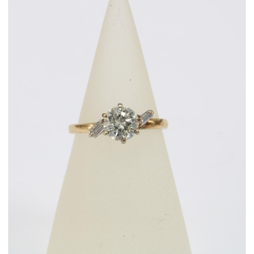 79 - Diamond ring with a claw set diamond flanked by baguette gems, possibly moissanites, on an unmarked ... 