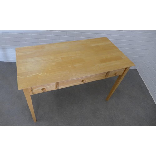 417 - Modern beechwood desk/table the rectangular top above two frieze drawers and one fall front drawer, ... 