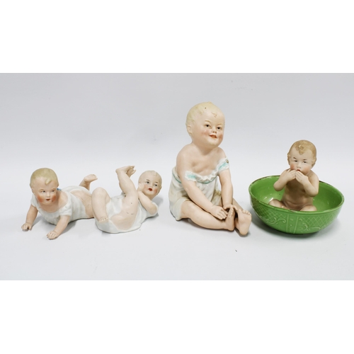 117 - Four bisque piano babies to include Gebruder Heubach, one in a green bowl, tallest 16cm (4)