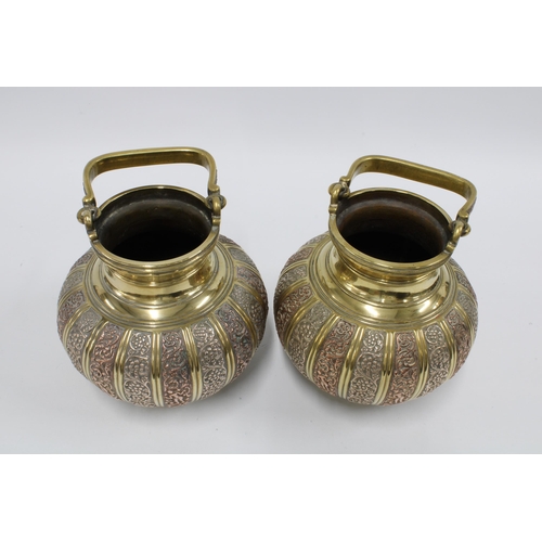 342 - A pair of brass bowls with swing handles and mixed metal pattern in relief,  16cm high excluding han... 