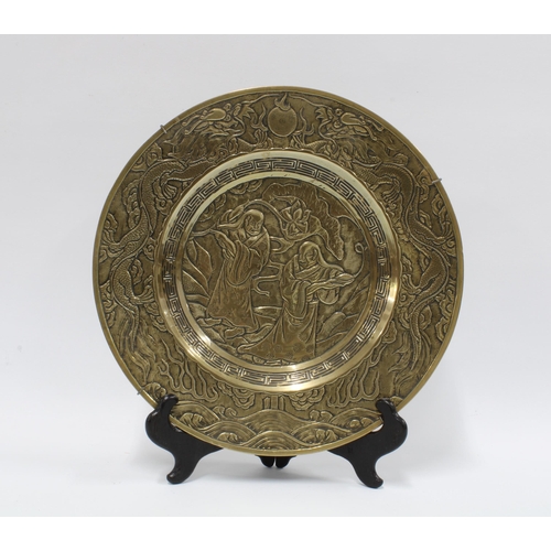 344 - Chinese brass charger with two figures and lotus leaves within a dragon border, 27cm diameter