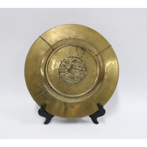 344 - Chinese brass charger with two figures and lotus leaves within a dragon border, 27cm diameter