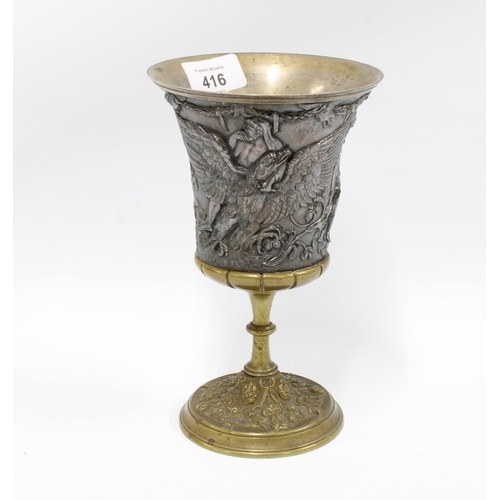 416 - Mixed metal goblet, the flared bowl with classical figures in relief on a knop stem with circular fo... 