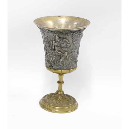 416 - Mixed metal goblet, the flared bowl with classical figures in relief on a knop stem with circular fo... 