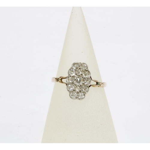 36 - Diamond dress ring, the central claw set diamond within a surround of twelve smaller diamonds, set i... 