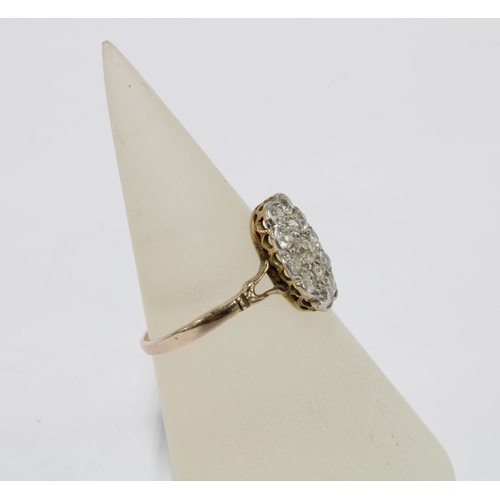 36 - Diamond dress ring, the central claw set diamond within a surround of twelve smaller diamonds, set i... 