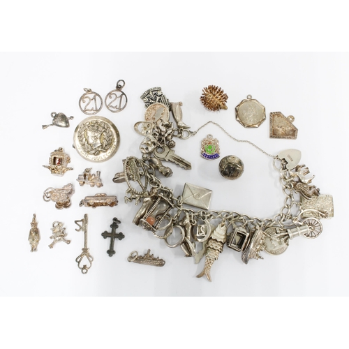 40 - Vintage silver charm bracelet with a heart shaped padlock together with a quantity of loose charms