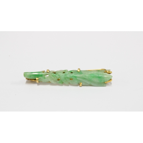 67 - A jade brooch set in unmarked yellow metal, a jadeite pendant in yellow metal frame on a 9ct gold ch... 