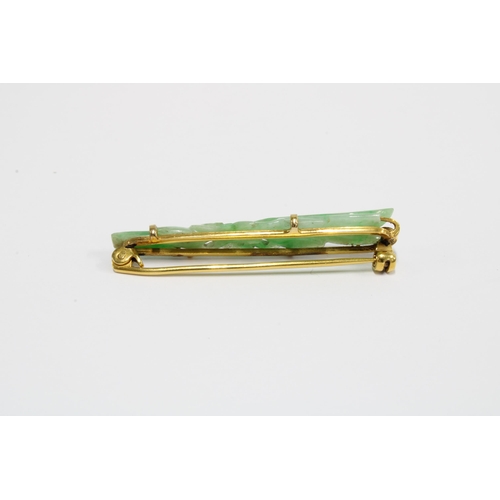 67 - A jade brooch set in unmarked yellow metal, a jadeite pendant in yellow metal frame on a 9ct gold ch... 