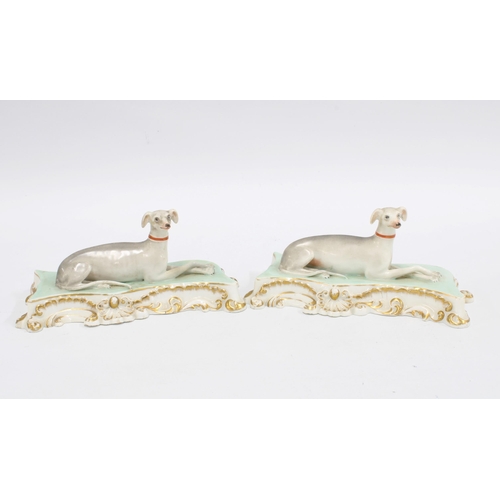 83 - A pair of Paris (Jacob Petit) porcelain greyhound figures, with red collars and sat upon gilt edged ... 