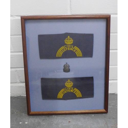 456 - Showcase frame containing an ARP badge and two Civil Defence sleeve bands