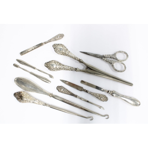 67 - A collection of silver and white metal handled shoe horns, button hooks, glove stretchers, scissors,... 