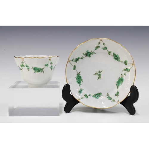 122 - 18th century Bristol porcelain teabowl and saucer painted with green floral swags and gilt edged bor... 