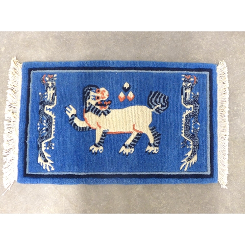 247 - Chinese rug / mat, blue field with a Buddhistic lion,  85 x 46cm.