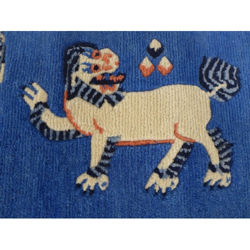 247 - Chinese rug / mat, blue field with a Buddhistic lion,  85 x 46cm.