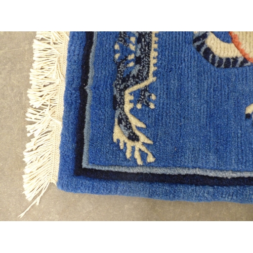 247 - Chinese rug / mat, blue field with a Buddhistic lion,  85 x 46cm.