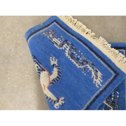 247 - Chinese rug / mat, blue field with a Buddhistic lion,  85 x 46cm.